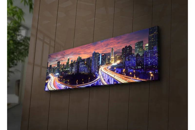 Canvas-taulu LED-valaistuksella 30x90 cm - Kaupungin siluetti hämärässä teiden valonsäteiden lumoissa, Tummansininen / Oranssi / Violetti
