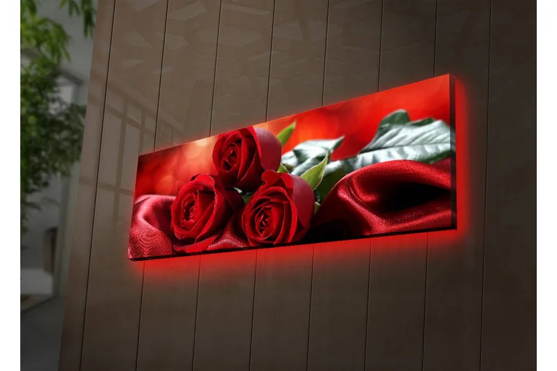 Canvas-taulu LED-valaistuksella 30x90 cm - Kolme punaista ruusua pehmeällä, punaisella satiinitaustalla, Punainen / Vihreä