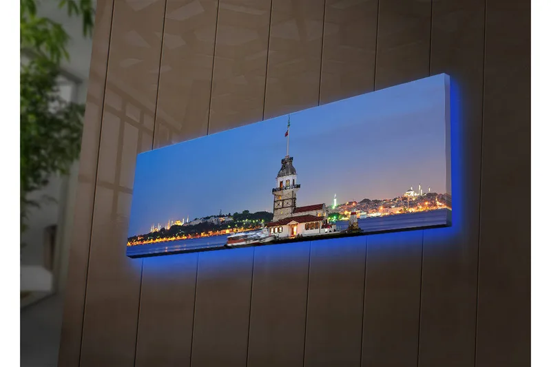 Canvas-taulu LED-valaistuksella 30x90 cm - Näkymä historiallisesta majakasta meren rannalla hämärässä, Sininen / Valkoinen / Harmaa