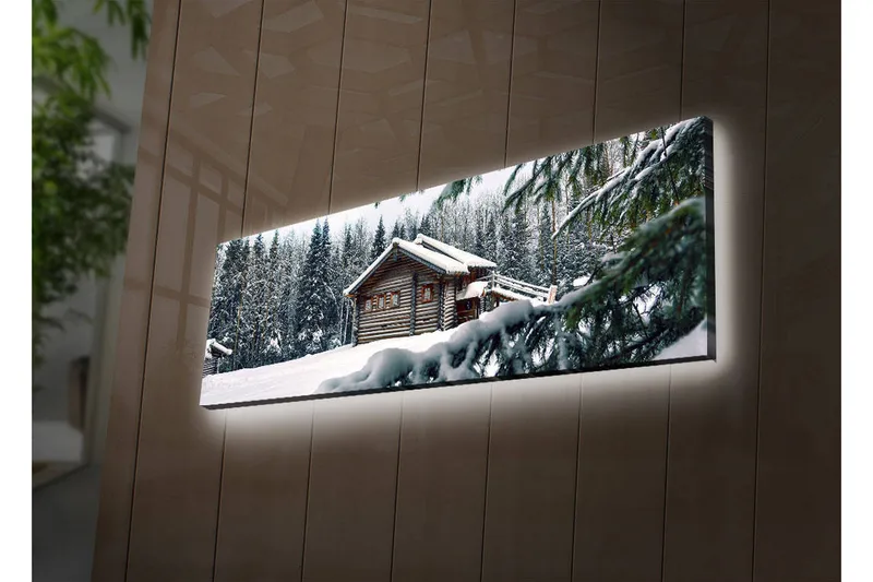 Canvas-taulu LED-valaistuksella 30x90 cm - Talvimaisema mökillä, jota ympäröi lumi ja kuusia, Valkoinen / Vihreä / Ruskea