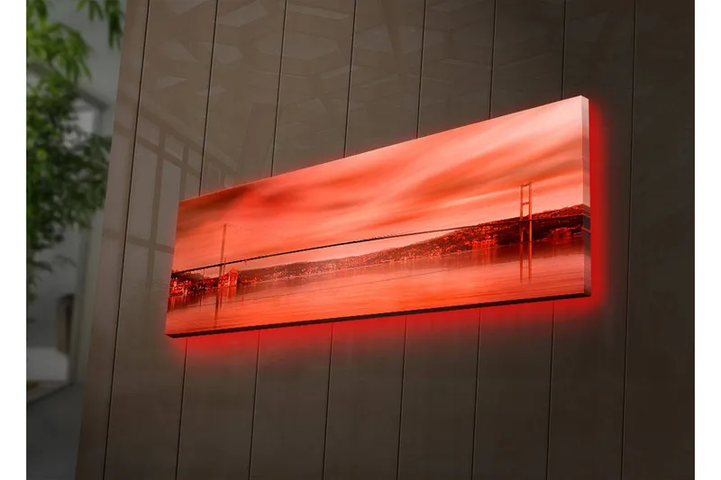Canvas-taulu LED-valaistuksella 30x90 cm - Upea näkymä sillasta peilimäisen vedenpinnan yli auringonlaskun väreissä, Punainen / Oranssi / Musta
