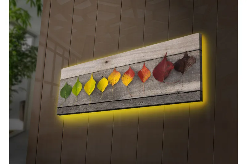 Canvas-taulu LED-valaistuksella 30x90 cm - Värikkäitä lehtiä rivissä puulevyllä, Vihreä / Keltainen / Punainen