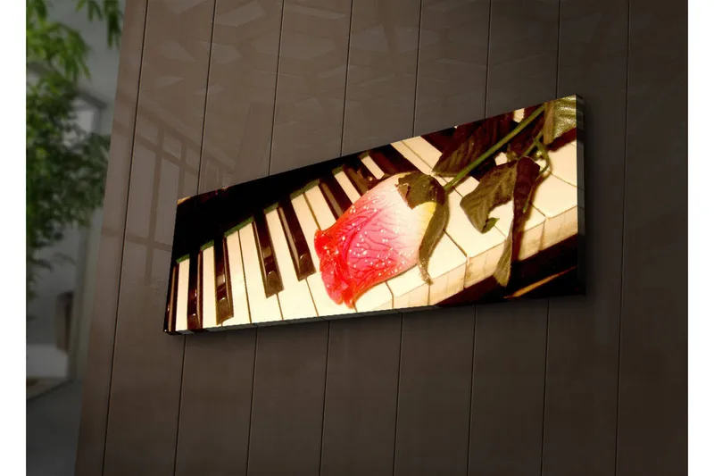 Canvas-taulu LED-valaistuksella 30x90 cm - Punainen ruusu pianolla mustavalkoisilla koskettimilla, Punainen / Musta / Valkoinen