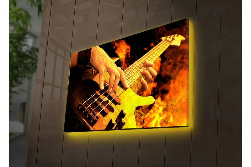 Canvas-taulu LED-valaistuksella 45x70 cm - Kitaristi soittaa sähköbassoa tulisien liekkien ympäröimänä, Oranssi / Musta / Keltainen