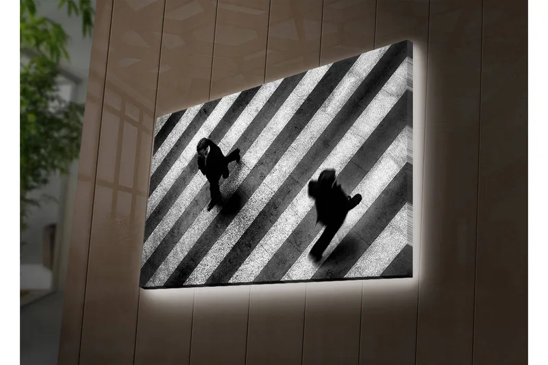Canvas-taulu LED-valaistuksella 45x70 cm - Mustavalkoiset siluetit ihmisistä, jotka ylittävät suojatietä, Musta / Valkoinen