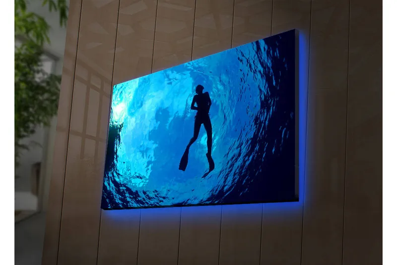 Canvas-taulu LED-valaistuksella 45x70 cm - Sukeltajan siluetti kirkkaan sinisessä vedessä, Tummansininen / Vaaleansininen