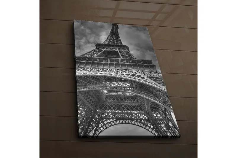 Canvas-taulu LED-valaistuksella 70x45 cm - mustavalkoinen kuva Eiffel-tornista dramaattisesta kulmasta katsottuna, Musta / Valkoinen / Harmaa