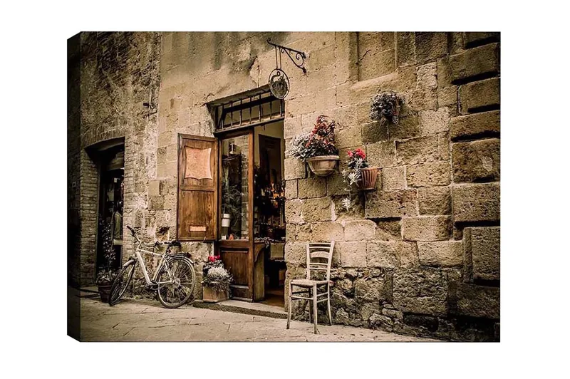 Canvas-taulu - Viehättävä katukuva polkupyörällä ja avoimella ovella kauppaan, Beige / Ruskea / Vihreä