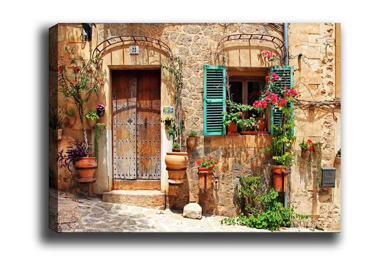 Canvas-taulu - Viehättävä talon julkisivu kukilla ja vihreillä ikkunaluukuilla, Terrakotta / Vihreä / Beige