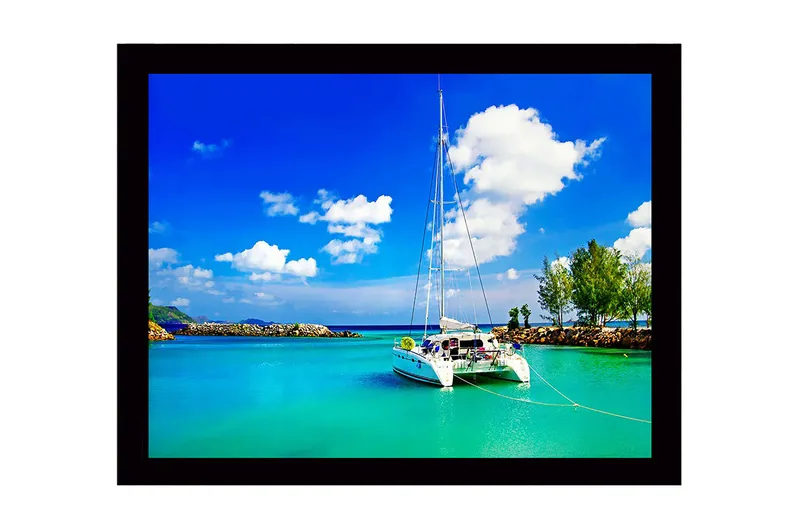 Kehystetty puutaulu - 41x56 cm - Purjevene kirkkaassa, turkoosissa laguunissa sinisen taivaan alla valkoisten pilvien kanssa, Turkoosi / Sininen / Valkoinen
